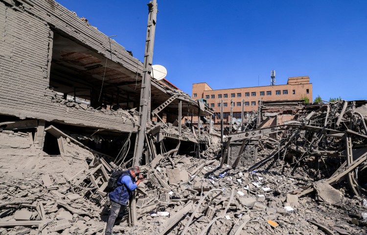 Journalists film at a damaged area following strikes on Sharif University of Technology in Tehran on April 7, 2026.