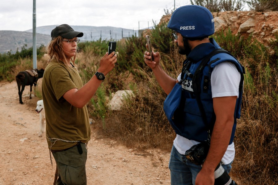 An Israeli settler records a Palestinian journalist using his mobile phone, who in turn records the settler, as they cover the demolition of Palestinian-owned buildings on the outskirts of Birzeit in the Israeli-occupied West Bank, on August 31, 2026.